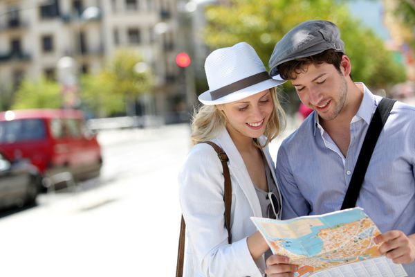 زن و شوهر جوان مرسوم در شهر با نقشه توریستی