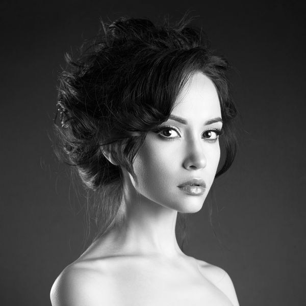 پرتره هنر استودیو زن زیبا با مدل موهای زیبا در پس زمینه سیاه و سفید