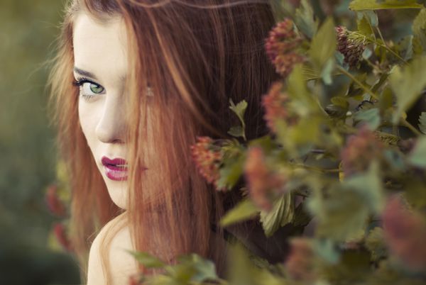 زن جوان زیبا مو قرمز در پارک