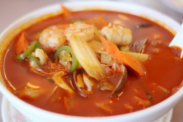 کاسه سوپ غذاهای دریایی تند در یک رستوران چینی