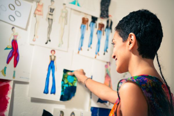 جوانان و کسب و کار کوچک زن اسپانیایی در کار به عنوان طراح و خیاط مد نگاه کردن به طرح های مجموعه جدید در atelier