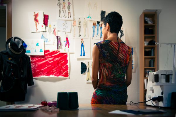 جوانان و کسب و کار کوچک زن اسپانیایی در کار به عنوان طراح و خیاط مد نگاه کردن به طرح های مجموعه جدید در atelier