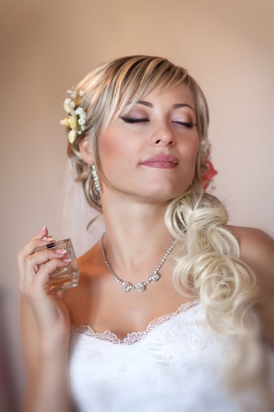 عروس زیبا در لباس عروسی سفید با مدل موهای و آرایش روشن دختر مبارک منتظر داماد خانم رمانتیک در لباس عروسی و گل در مو آماده نهایی برای عروسی است