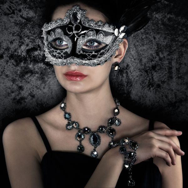زن زیبا در کارناوال ماسک در پس زمینه مخملی تاریک