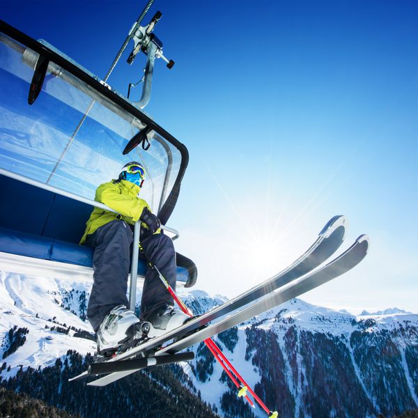 اسکی باز در بالای کوهستان نشسته است