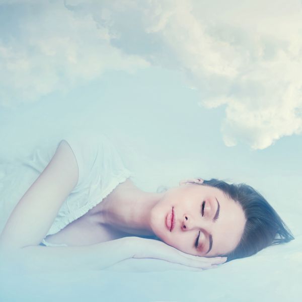دختر جوان زیبا خوابیدن و خوابیدن در ابرها