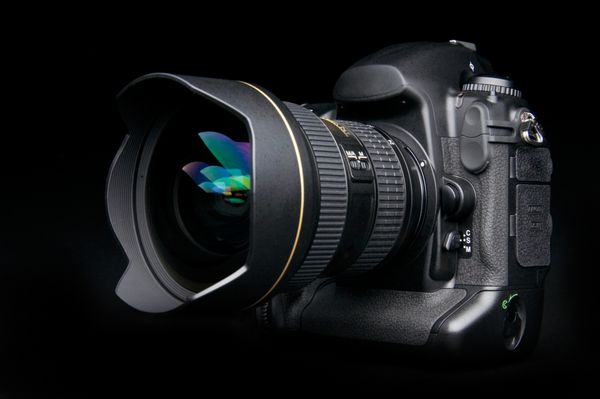 دوربین حرفه ای دیجیتال با لنز زوم در پس زمینه سیاه و سفید