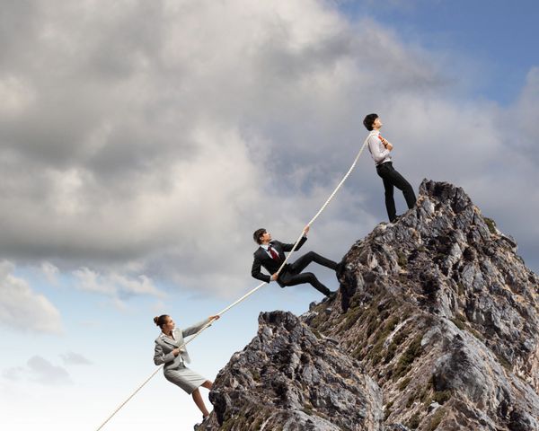 تصویری از سه کارگر کشیدن طناب در بالای کوه