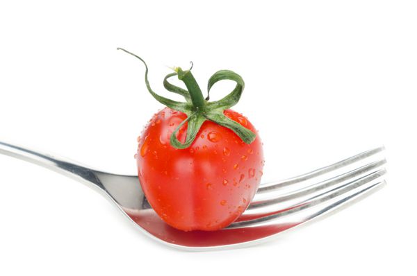 گوجه فرنگی گیلاس تازه بر روی یک چنگال جدا شده بر روی زمینه سفید