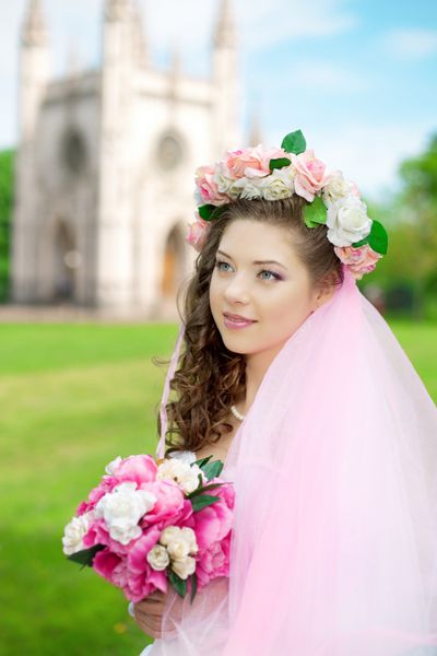 عروس جوان زیبا در گلدان گل روی سرش
