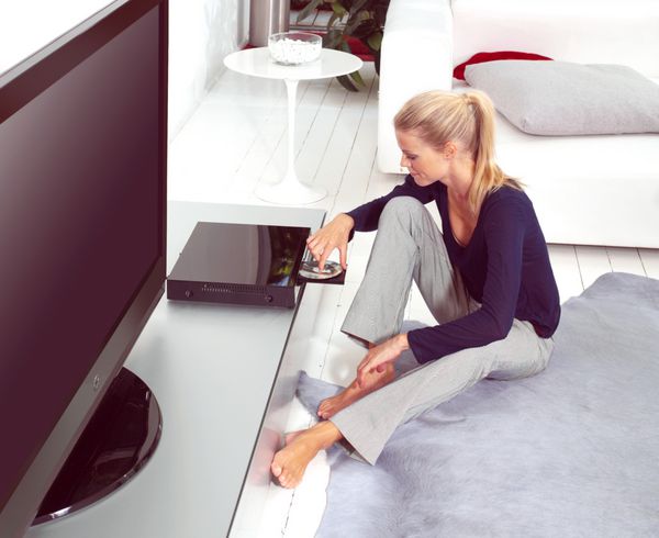زن با استفاده از پخش کننده دی وی دی در آپارتمان او