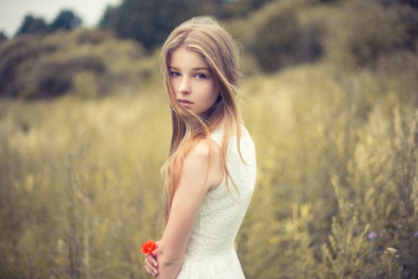 دختر زیبا با یک گل در زمینه