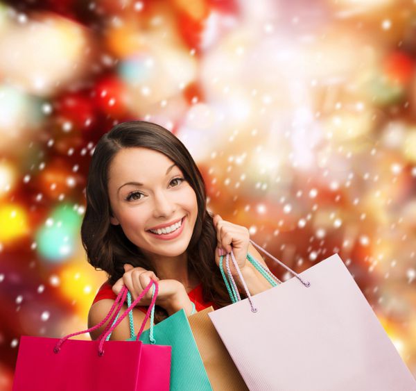خرید فروش هدیه کریسمس مفهوم x-mas لبخند زن در لباس قرمز با کیسه های خرید