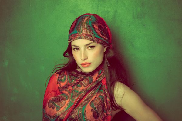 زیبا زن شرقی با روسری در زمینه سبز