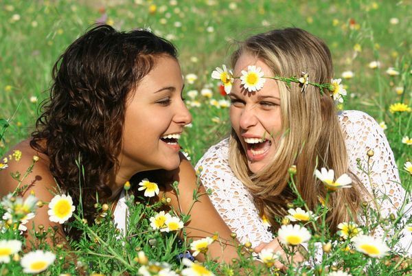 2 دختر خندیدن در گل آفتابگردان