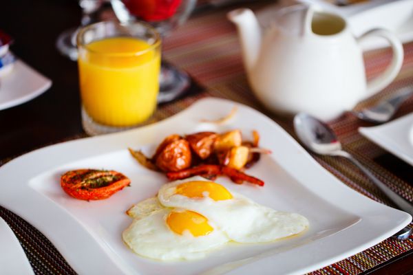 صبحانه خوشمزه با تخم مرغ سرخ شده سبزیجات آب پرتقال و قهوه