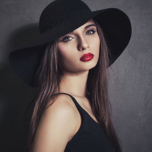 پرتره زن زیبا زن جوان زیبا در کلاه با لب قرمز