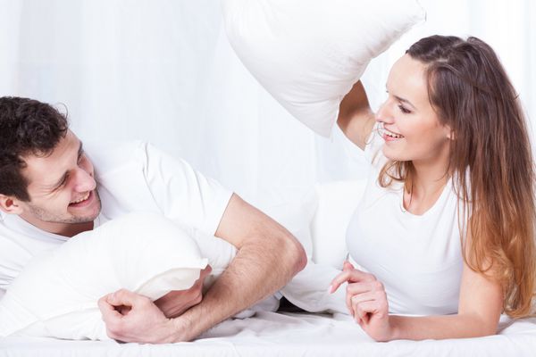 یک زن و شوهر خوش شانس داشتن یک بالش در رختخواب