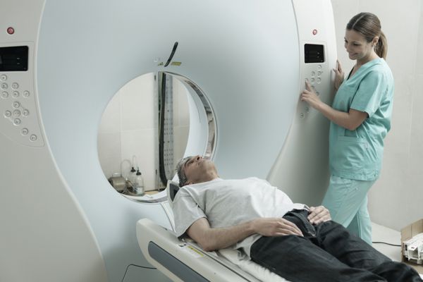 زن جوان دکتر مردانه در 40 سالگی با CT اسکنر را بررسی می کند توموگرافی کامپیوتری