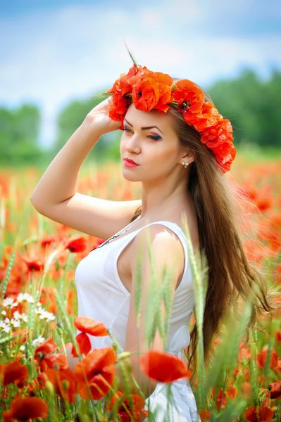 زن جوان زیبا در زمینه خشخاش قرمز روشن پرتره تابستانی