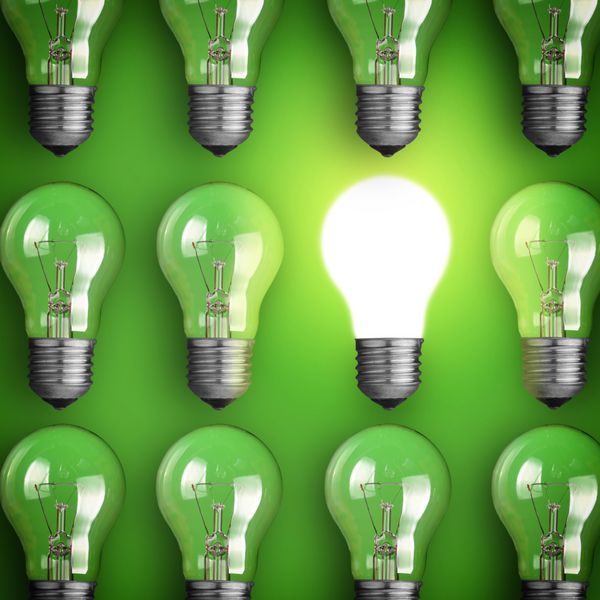 مفهوم ایده بزرگ لامپ درخشان در زمینه سبز