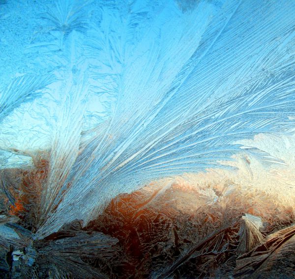 الگوی یخ در پنجره در فصل زمستان