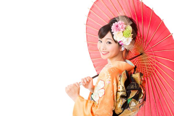 زن آسیایی جذاب پوشیدن کیمونو سنتی در پس زمینه سفید