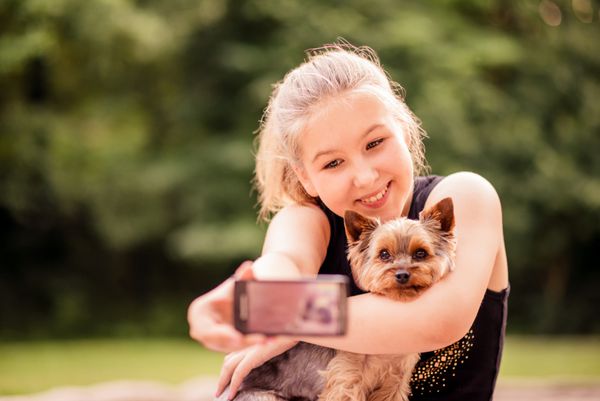 کودک گرفتن عکس از خود و سگ خود را در فضای باز در طبیعت