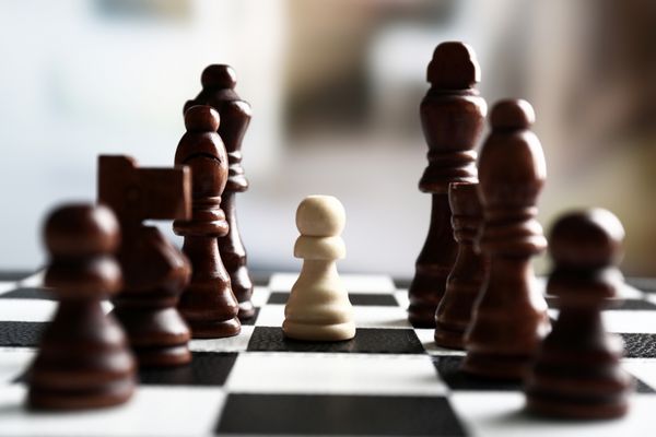 هیئت مدیره شطرنج با قطعات شطرنجی در پس زمینه نور