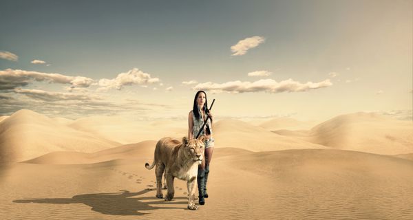 زن زیبا با شیر در صحرا
