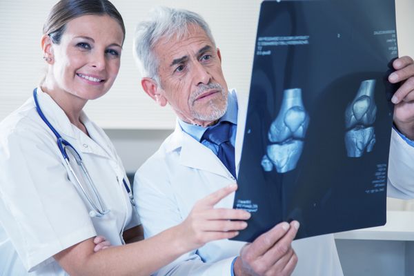 دکتر بالغ و دستیار زن جوان در حال آزمایش بیمار اشعه ایکس