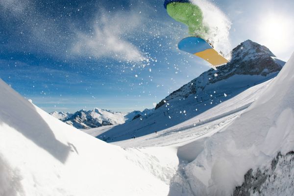 عکس از پریدن snowboarder بیش از کوهستان در رفت و آمد مکرر زمستان