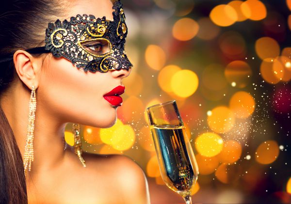 زن مدل با شیشه ای از شامپاین پوشیدن وینتیان masquerade ماسک کارناوال در حزب نوشیدن شامپاین بر روی تعطیلات طلایی درخشان پس زمینه کریسمس جشن سال نو آرایش کامل
