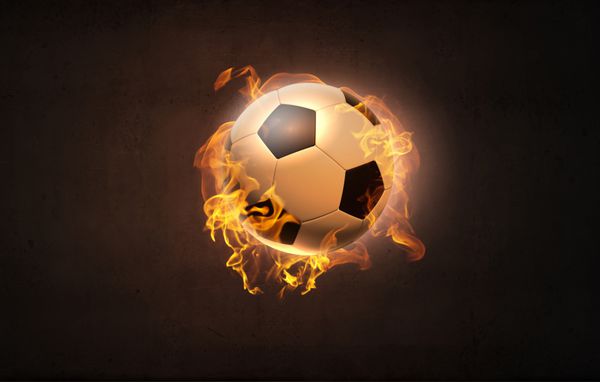 تصویر مفهومی توپ فوتبال در شعله های آتش
