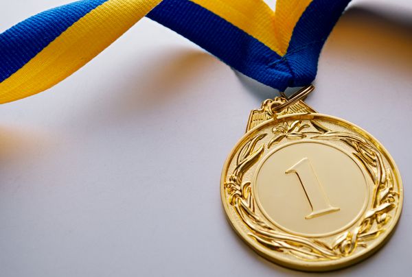 مدال طلا در پیش زمینه روی روبان آبی رنگ زرد