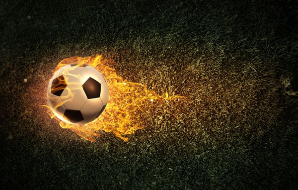 تصویر مفهومی توپ فوتبال در شعله های آتش