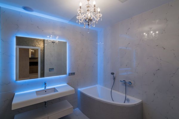 حمام داخلی با یک حمام و یک آینه با نور پس زمینه آبی نرم
