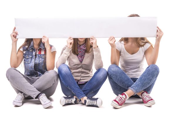 سه دختر که نشسته اند روی صندلی و به صورت جداگانه روی میز سفید با فضای خالی برای متن نشسته اند جدا شده بر روی زمینه سفید
