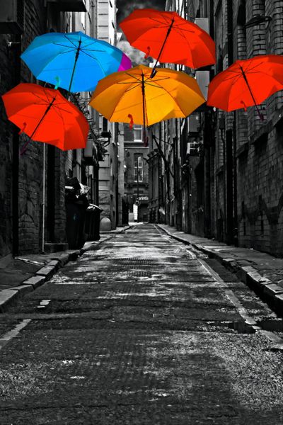 یک نقاشی دیجیتالی ساخته شده از چتر های رنگارنگ در کوچه خیابان تاریک پشت