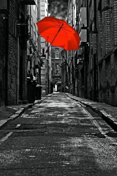 یک نقاشی دیجیتالی ساخته شده از یک چتر رنگی در کوچه خیابان تاریک