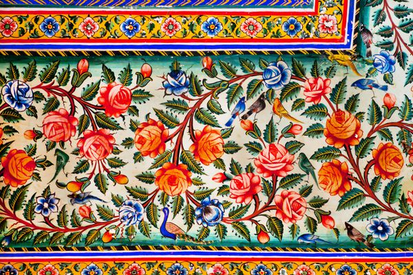 گل ها و پرندگان کوچک طراحی شده در نقاشی رنگارنگ عمارت تاریخی در راجستان هند