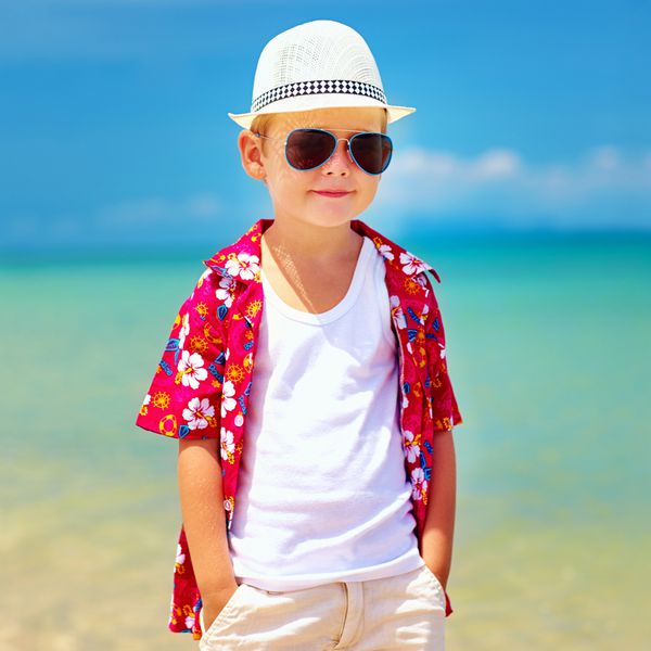 پسر ناز مدرن راه رفتن در ساحل تابستان