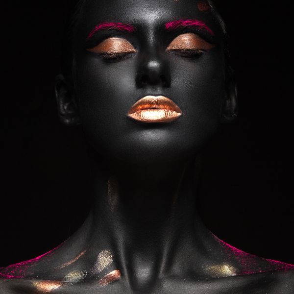 پرتره مد یک دختر سیاه پوست با رنگ makeupFeauty صورت تصویر گرفته شده در استودیو در پس زمینه سیاه و سفید