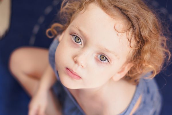 تصویر کوچک نزدیک یک دختر کوچک ناز با موهای فرفری