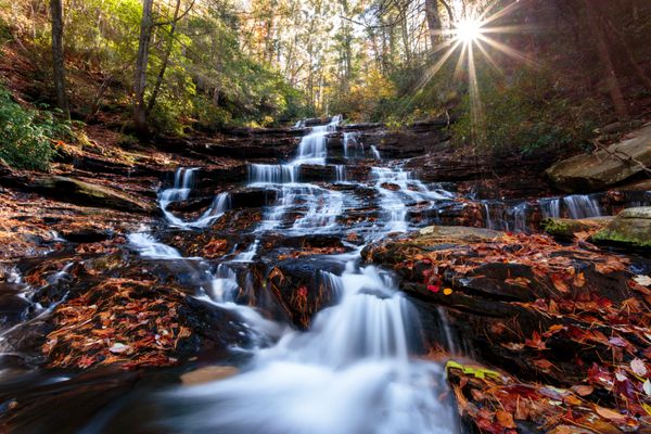 آبشار با غروب خورشید در پس زمینه رنگ پاییز شمال گرجستان ایالات متحده آمریکا