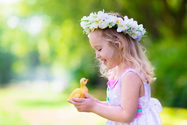 دختر کوچک سرگرم کننده در شکار تخم مرغ عید پاک بچه در تاج گل با اردک اسباب بازی یا مرغ کودکان در حال جستجو برای تخم مرغ در باغ بچه های کوچک کودک در فضای باز کودک مبارک خنده و لبخند زدن