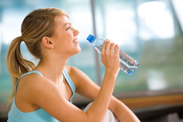 مشخصات زن زیبای رفتن به نوشیدن آب از بطری های پلاستیکی پس از تمرین