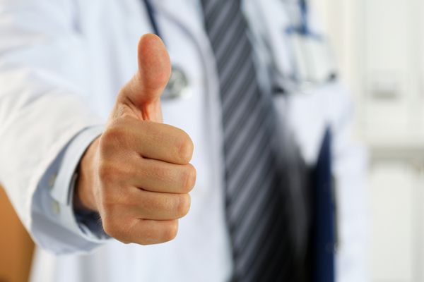 دکتر دکتر مرد با داشتن پد سند در دست نشان دادن OK یا تایید نشانه با انگشت شست خدمات پزشکی بالا و کیفیت بهترین درمان و مفهوم مراقبت از بیمار رضایت کارمند
