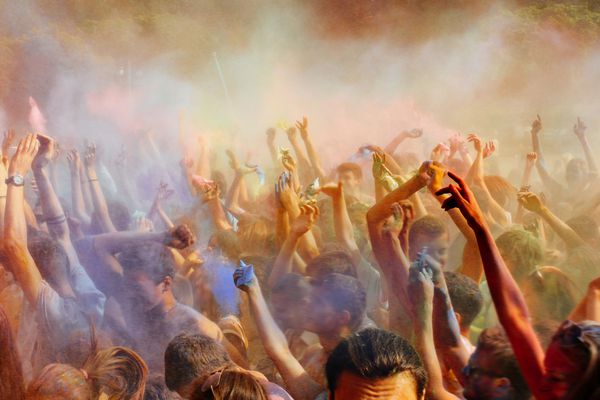 مردم در حال برگزاری مهمانی زیر ابر پودر رنگارنگ در جشن هالی جشنواره رنگ در تابستان لحظه شگفت انگیز است