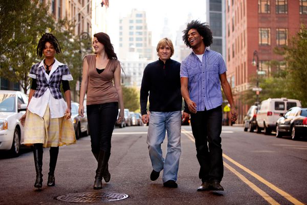 گروهی از جوانان که در خیابان یک شهر بزرگ راه می روند